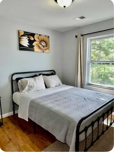 a bed in a bedroom with a window at Luxurious, Spacious, Modern 6 BR Escape with parkings and sleeps up to 16 in Irvington