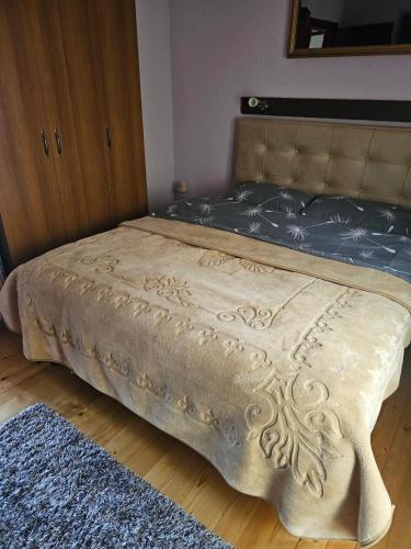 a bed in a bedroom with a brown blanket on it at MM Apartments in Žabljak