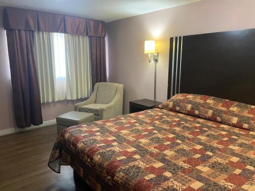 a hotel room with a bed and a chair at Finn's Motel in Saint James