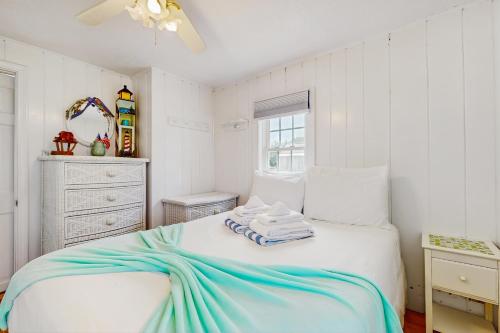 a bedroom with a bed with a blue blanket on it at The Jib & The Genoa in Dennis Port