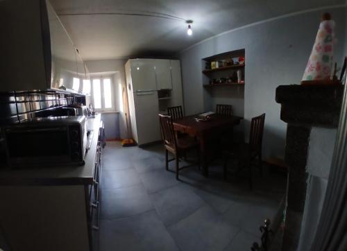 a small kitchen with a table and a refrigerator at Da Nonno in Montegiovi