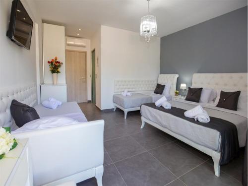 a living room with two beds and a television at Astris Sun Hotel in Astris