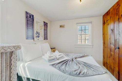 a bedroom with a bed with towels on it at The Jib & The Genoa in Dennis Port