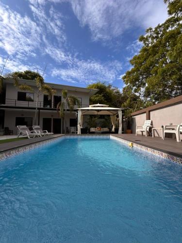 a swimming pool in front of a house at OCEAN DRIVE LODGE in Montañita