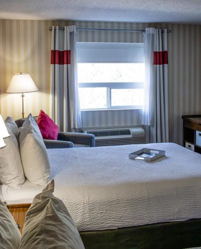 a hotel room with a bed and a window at Prestige Prince George Lodge in Prince George