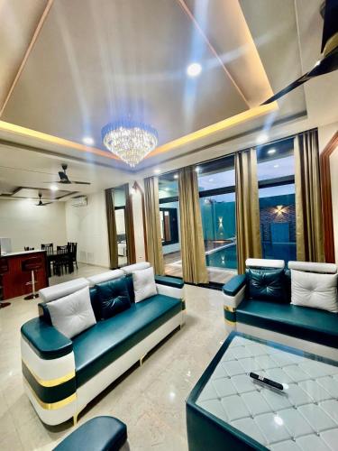 a living room with two couches and a table at ZenRoofs - Pool Farm House in Jaipur
