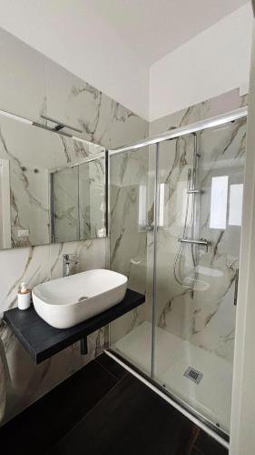 a bathroom with a sink and a shower at Helios Home in Reggio Calabria