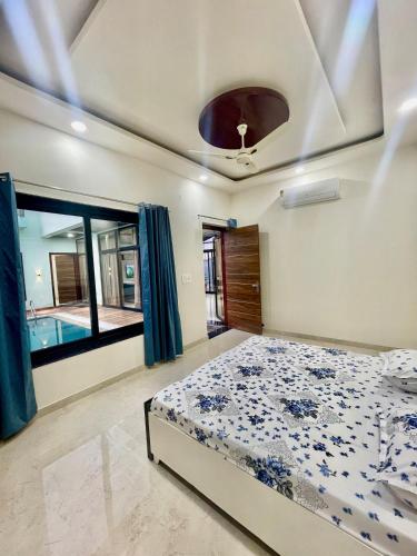 a bedroom with a bed and a swimming pool at ZenRoofs - Pool Farm House in Jaipur