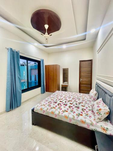 a bedroom with a bed and a large window at ZenRoofs - Pool Farm House in Jaipur