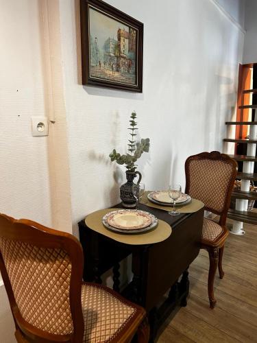 a table with two plates and a vase on it at Un petit Air de Campagne -4km d'Amboise in Chargé