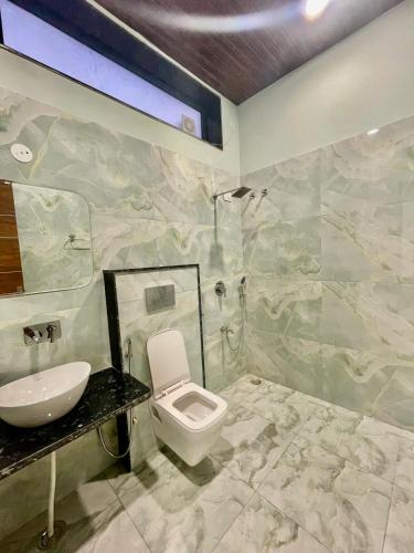 a bathroom with a white toilet and a sink at ZenRoofs - Pool Farm House in Jaipur