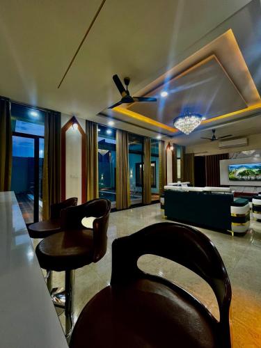 a large living room with chairs and a couch at ZenRoofs - Pool Farm House in Jaipur