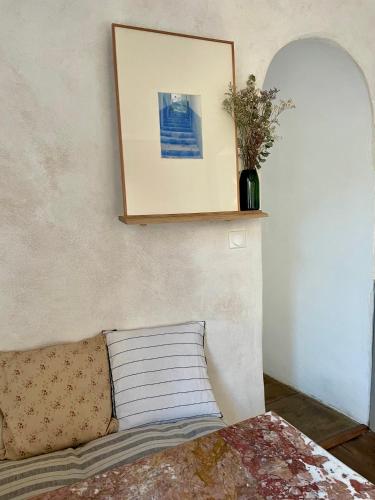 a picture on a wall above a bed with a pillow at Le Cocand in Autun