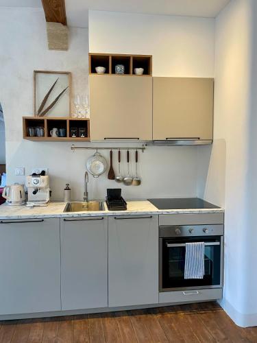 a kitchen with white cabinets and a sink at Le Cocand in Autun