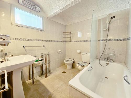 Un baño con bañera, inodoro y lavabo. en Golden Bay beach house by Lica, en Estepona