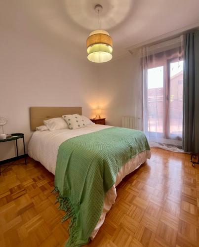 a bedroom with a bed with a green blanket at Casa Yayi in Luanco