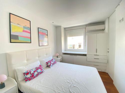 a bedroom with a white bed with two pillows on it at Apartamento Plaza España in Madrid