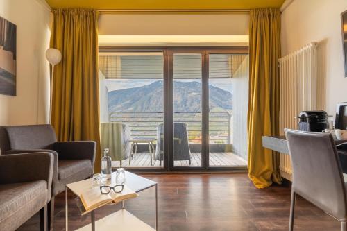 a living room with a view of a mountain at Hotel Gartner in Tirolo