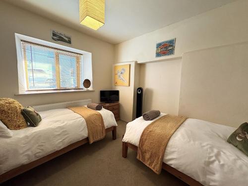 Un dormitorio con dos camas y una ventana. en 3 Bed in Braunton 86704, en Braunton