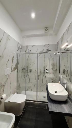 a bathroom with a shower and a toilet and a sink at Helios Home in Reggio Calabria