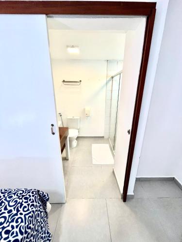 a bedroom with a door leading to a bathroom at Pousada Tô na Praia Juquehy in Juquei