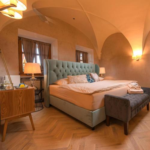 a bedroom with a large bed with a blue headboard at Vila Zipser in Poprad