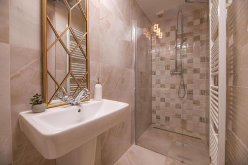 a white bathroom with a sink and a shower at Vila Zipser in Poprad