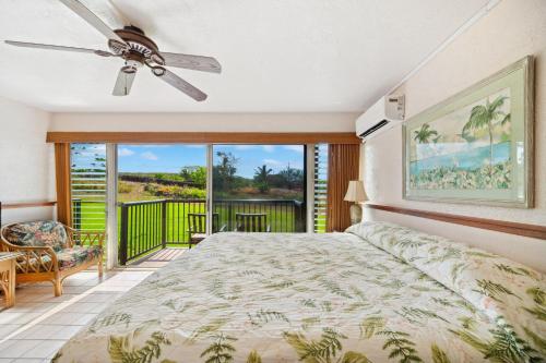 a bedroom with a bed and a balcony at Prince Kuhio 115 in Kipu
