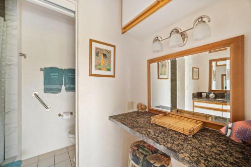 a bathroom with a sink and a mirror at Prince Kuhio 115 in Kipu