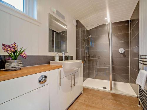 Un baño blanco con lavabo y ducha. en 1 Bed in Langbank 73846, en Langbank