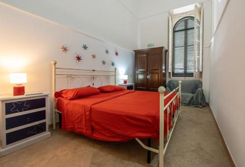 a bedroom with a bed with a red bedspread at Palazzo Caputo in Nardò