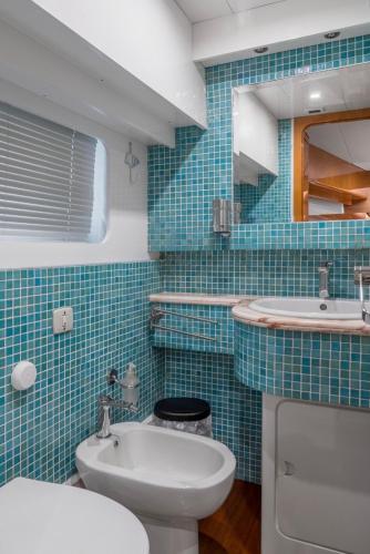 a blue tiled bathroom with a toilet and a sink at La Giorgia Boat in Lacco Ameno
