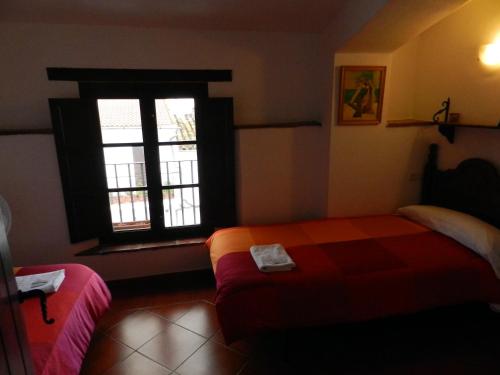a bedroom with a bed and a window at Posada La Casa Grande in Jimena de la Frontera