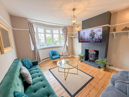 a living room with a blue couch and a fireplace at Spacious 3BDR House in New Malden with FREE Parking and Garden near Kingston upon Thames, Wimbledon & Raynes Park by Staylio London in Worcester Park