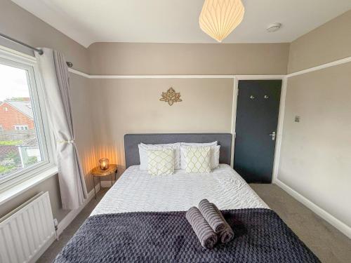 a bedroom with a bed with a large window at Spacious 3BDR House in New Malden with FREE Parking and Garden near Kingston upon Thames, Wimbledon & Raynes Park by Staylio London in Worcester Park