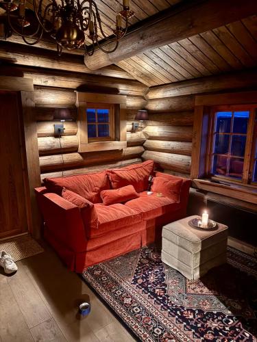 a living room with a red couch and a table at Geilo - Charming cottage with a stunning view in Geilo
