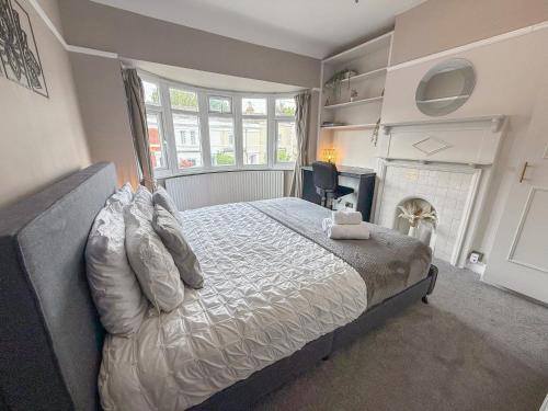 a bedroom with a bed and a fireplace at Spacious 3BDR House in New Malden with FREE Parking and Garden near Kingston upon Thames, Wimbledon & Raynes Park by Staylio London in Worcester Park