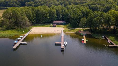 an aerial view of a dock with boats in the water at Biały domek nad jeziorem in Stegers