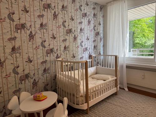 a baby room with a crib and a table at Luxury, quiet flat overlooking Zurich in Zürich
