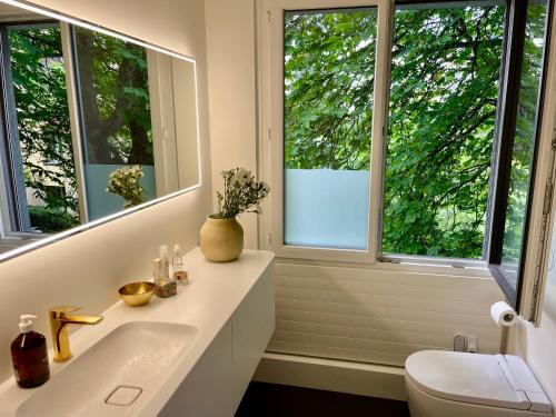 a bathroom with a sink and two windows at Luxury, quiet flat overlooking Zurich in Zürich