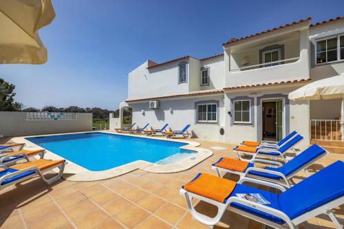 a villa with a swimming pool in front of a house at Villa Canas by Villa Plus in Vale do Lobo