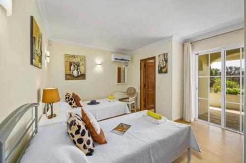 ヴァーレ・ド・ローボにあるVilla Canas by Villa Plusのベッド2台とバルコニー付きのホテルの部屋