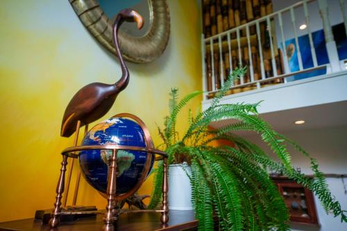 a bird statue sitting on a table next to a plant at Gîte Crystal Inn in Mont-Tremblant