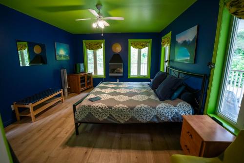 a bedroom with blue and green walls and a bed at Gîte Crystal Inn in Mont-Tremblant