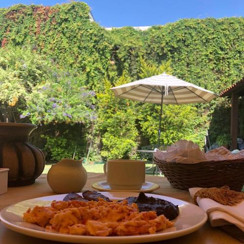 a plate of food on a table with an umbrella at Hostal Villa Toscana in Guatemala