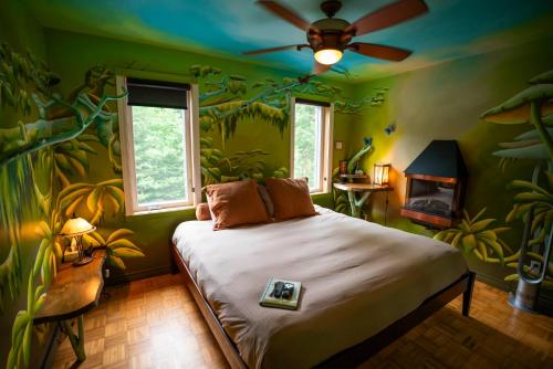 a bedroom with a bed with green walls and a ceiling at Gîte Crystal Inn in Mont-Tremblant