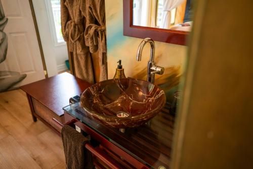 a bathroom with a copper sink on a table at Gîte Crystal Inn in Mont-Tremblant