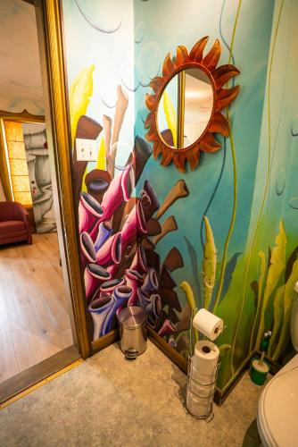 a bathroom with a painting on the wall at Gîte Crystal Inn in Mont-Tremblant