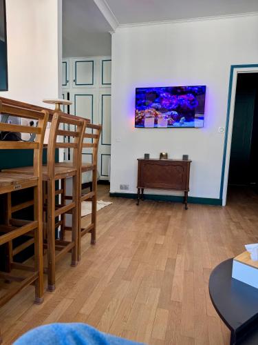 a living room with wooden chairs and a painting on the wall at Le Studio du Coq - Proche du Zoo de Beauval et des châteaux in Selles-sur-Cher