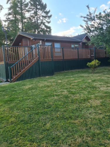 a fence in front of a house with a yard at 46A Golf view lodge lilliardsedge in Jedburgh
